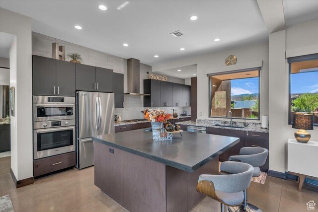 644 W Wild Indigo Way, Ivins, UT 84738 - kitchen with wall chimney range hood, a sink, stainless steel appliances, a center island, and a kitchen bar