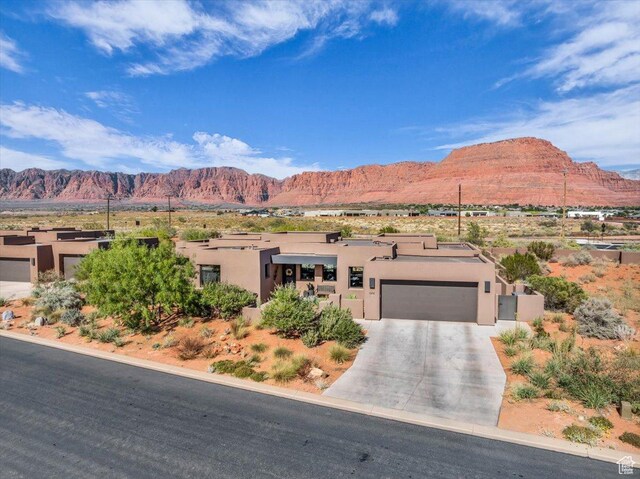 644 W Wild Indigo Way, Ivins, UT 84738 - view of front of property with a mountain view, a garage, stucco siding, and concrete driveway