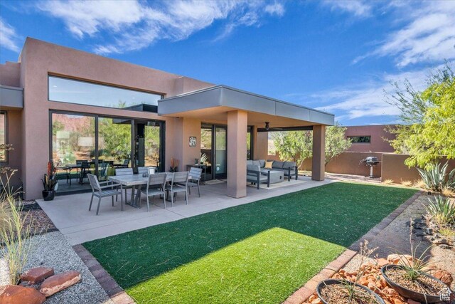 644 W Wild Indigo Way, Ivins, UT 84738 - back of property with a lawn, an outdoor living space, stucco siding, and fence
