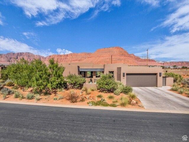 644 W Wild Indigo Way, Ivins, UT 84738 - pueblo revival-style home featuring a mountain view, stucco siding, driveway, and an attached garage