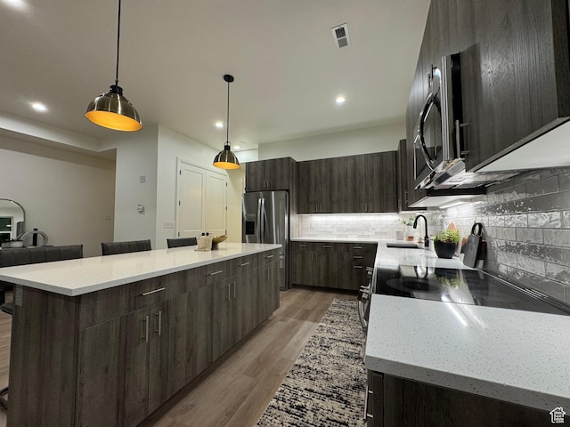136 S 700 E Unit 1, Salt Lake City, UT 84102 - kitchen with sink, decorative light fixtures, appliances with stainless steel finishes, a kitchen island, and backsplash
