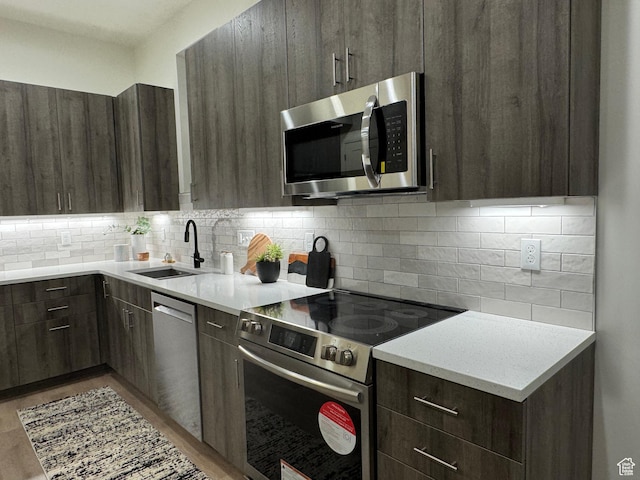 136 S 700 E Unit 1, Salt Lake City, UT 84102 - kitchen featuring tasteful backsplash, sink, dark brown cabinetry, and appliances with stainless steel finishes