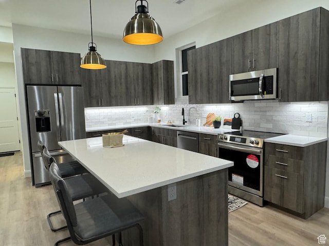136 S 700 E Unit 1, Salt Lake City, UT 84102 - kitchen with pendant lighting, a kitchen bar, a center island, light hardwood / wood-style floors, and stainless steel appliances