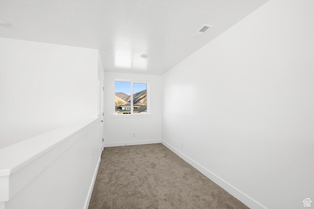 spare room featuring baseboards, carpet flooring, and visible vents