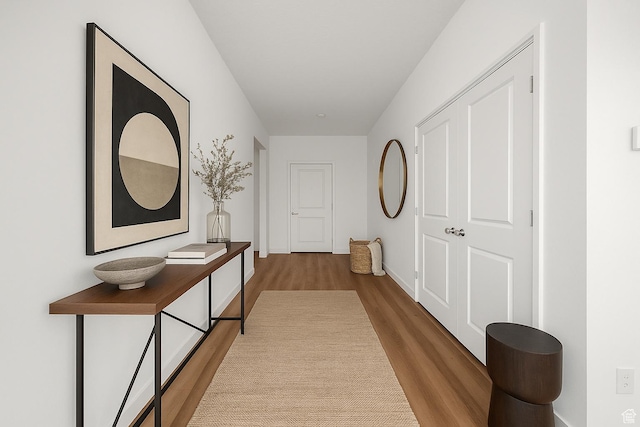 hall featuring baseboards and wood finished floors