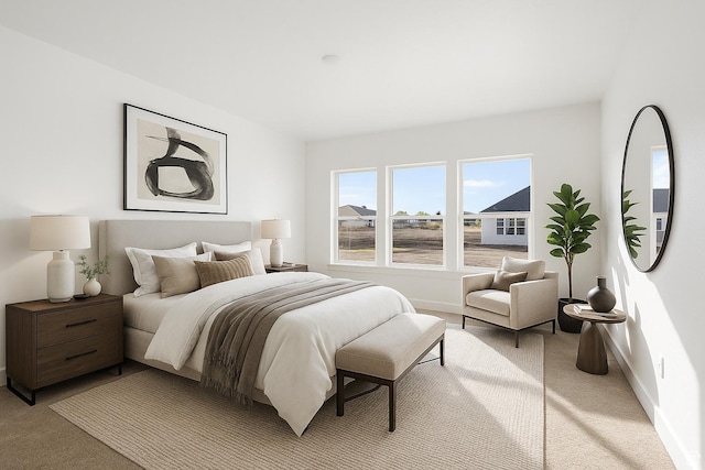 bedroom featuring baseboards and light colored carpet