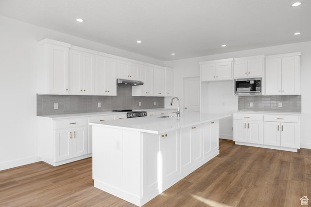 kitchen featuring recessed lighting, light countertops, tasteful backsplash, a sink, and appliances with stainless steel finishes