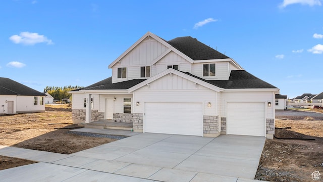modern farmhouse style home featuring board and batten siding, roof with shingles, stone siding, and concrete driveway