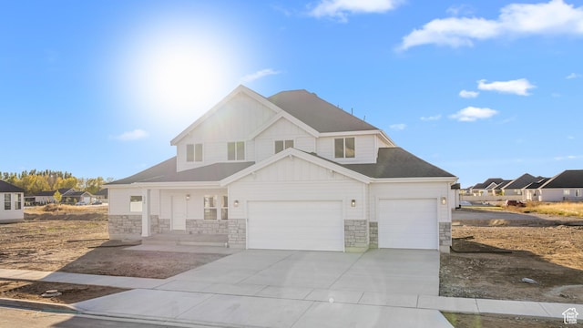 view of front facade featuring stone siding, a garage, board and batten siding, a porch, and driveway