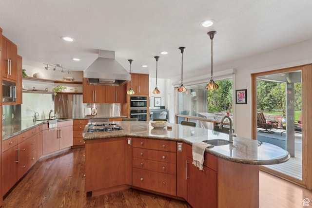 3797 Blacksmith Rd, Park City, UT 84098 - kitchen with island exhaust hood, appliances with stainless steel finishes, a sink, open shelves, and wood finished floors