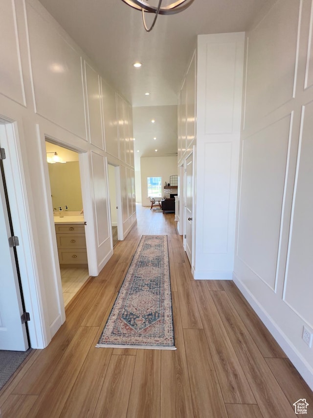 1491 N Starry Way Unit 218, Saratoga Springs, UT 84045 - hall featuring light wood-type flooring, a decorative wall, and recessed lighting