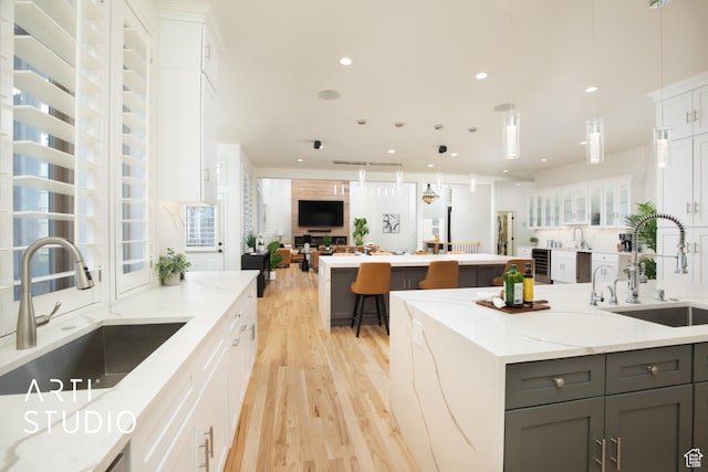 14714 S Pristine Dr E, Draper, UT 84020 - kitchen featuring a sink, a center island, light wood-style floors, and gray cabinetry