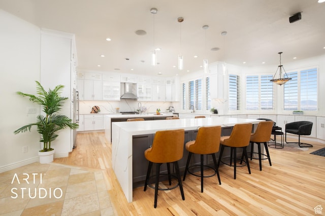 14714 S Pristine Dr E, Draper, UT 84020 - kitchen with white cabinets, light countertops, wall chimney exhaust hood, a large island, and glass insert cabinets