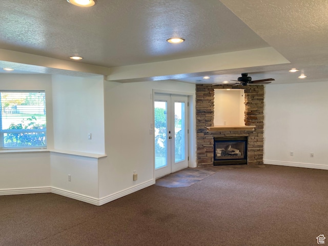 5046 W 4250 S, West Haven, UT 84401 - unfurnished living room with baseboards, a stone fireplace, a textured ceiling, french doors, and carpet flooring