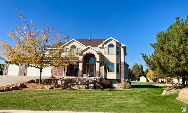 5046 W 4250 S, West Haven, UT 84401 - view of front of home featuring concrete driveway, brick siding, a front yard, and stucco siding
