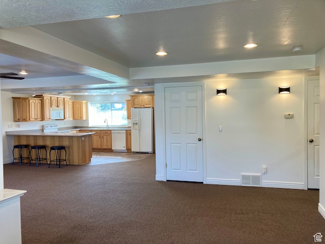5046 W 4250 S, West Haven, UT 84401 - kitchen with light countertops, dark carpet, white appliances, a peninsula, and a kitchen bar