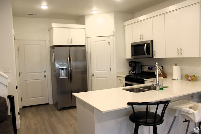 953 N 900 W, Tremonton, UT 84337 - kitchen with a peninsula, light wood-style flooring, appliances with stainless steel finishes, and a breakfast bar area