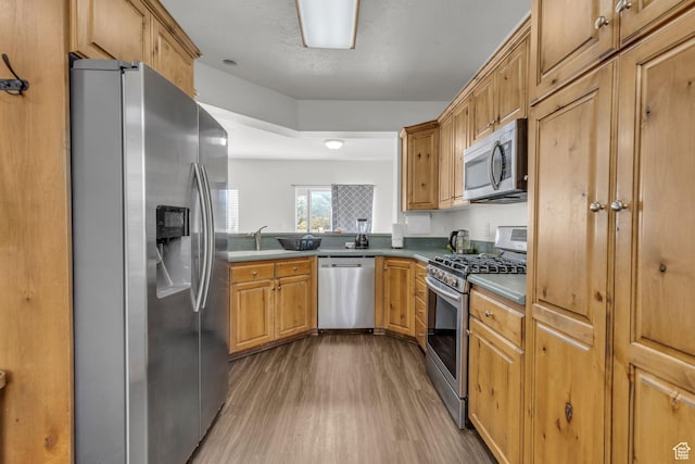 83 N 380 W, Orem, UT 84057 - kitchen with brown cabinets, appliances with stainless steel finishes, wood finished floors, and a sink