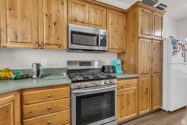 83 N 380 W, Orem, UT 84057 - kitchen featuring wood finished floors, brown cabinetry, and stainless steel appliances