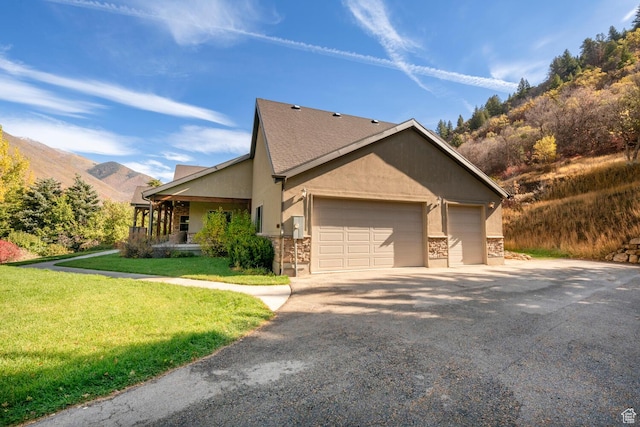 10569 S Covered Bridge Dr, Spanish Fork, UT 84660 - view of side of property with a mountain view, an attached garage, a yard, driveway, and stucco siding