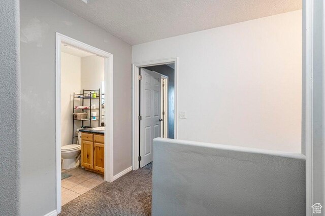 2668 N 550 W, Cedar City, UT 84721 - hallway with light colored carpet, light tile patterned floors, a sink, and a textured ceiling