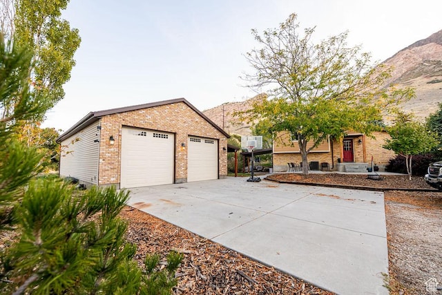 325 E 100 N, Willard, UT 84340 - view of front facade featuring brick siding, a garage, an outdoor structure, and a mountain view