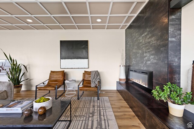 875 S Donner Way E Unit 111, Salt Lake City, UT 84108 - sitting room featuring coffered ceiling, baseboards, a tile fireplace, recessed lighting, and wood finished floors