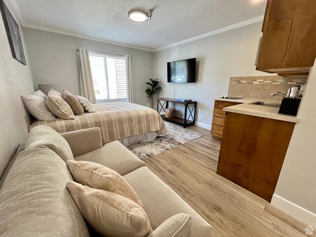 1940 Prospector Ave Unit 307, Park City, UT 84060 - bedroom featuring crown molding, a sink, light wood-type flooring, and baseboards