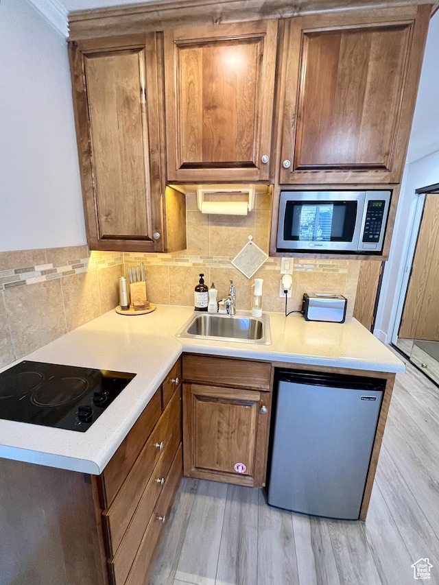 1940 Prospector Ave Unit 307, Park City, UT 84060 - kitchen with stainless steel microwave, a sink, fridge, black electric cooktop, and backsplash