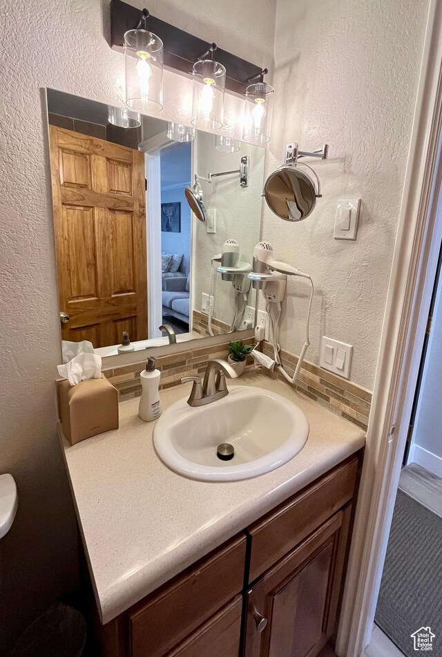 1940 Prospector Ave Unit 307, Park City, UT 84060 - bathroom featuring a textured wall, vanity, and decorative backsplash