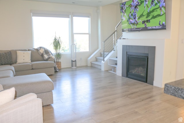 4172 S Kiera Hill Ln E, Millcreek, UT 84107 - living room featuring wood finished floors, a tiled fireplace, and stairs