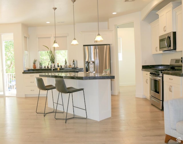 4172 S Kiera Hill Ln E, Millcreek, UT 84107 - kitchen featuring stainless steel appliances, a breakfast bar, recessed lighting, light wood-type flooring, and white cabinets