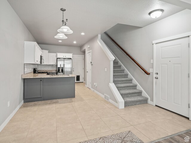 1138 N Shepard Creek Pkwy W Unit 2, Farmington, UT 84025 - kitchen with stainless steel appliances, a peninsula, white cabinets, backsplash, and hanging light fixtures