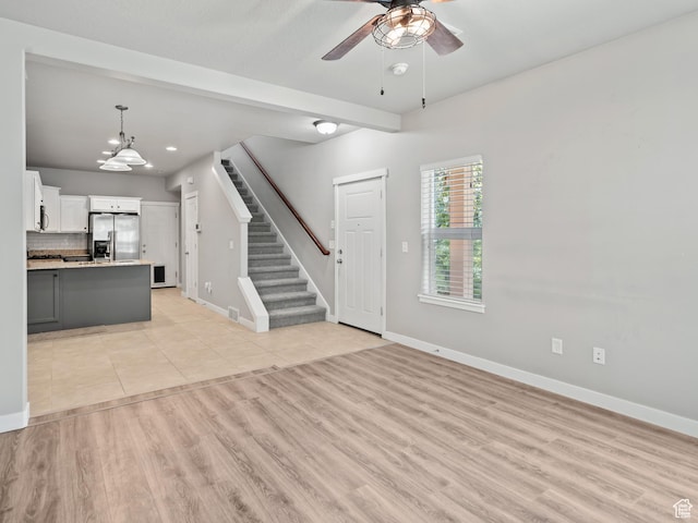 1138 N Shepard Creek Pkwy W Unit 2, Farmington, UT 84025 - unfurnished living room with ceiling fan, baseboards, a chandelier, stairs, and light wood-style flooring
