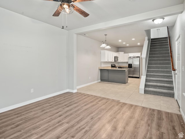 1138 N Shepard Creek Pkwy W Unit 2, Farmington, UT 84025 - unfurnished living room featuring a ceiling fan, stairs, baseboards, light wood-type flooring, and recessed lighting