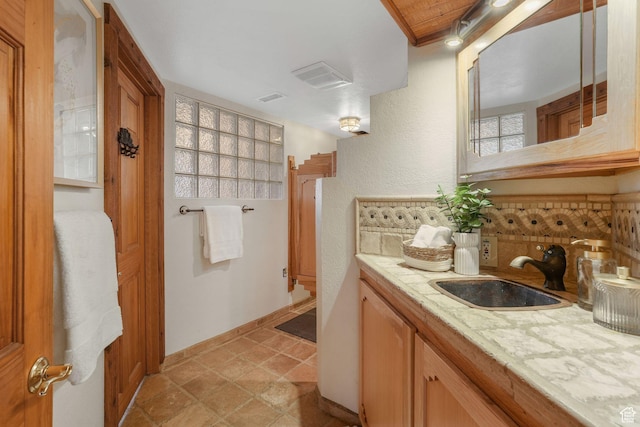 3640 E Aurora Cir, Salt Lake City, UT 84124 - bathroom featuring a textured wall, baseboards, backsplash, and vanity