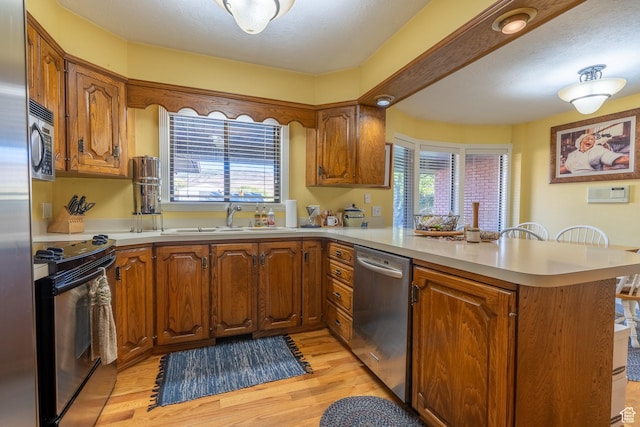 452 S 100 W, Salina, UT 84654 - kitchen featuring brown cabinetry, a peninsula, a sink, and appliances with stainless steel finishes