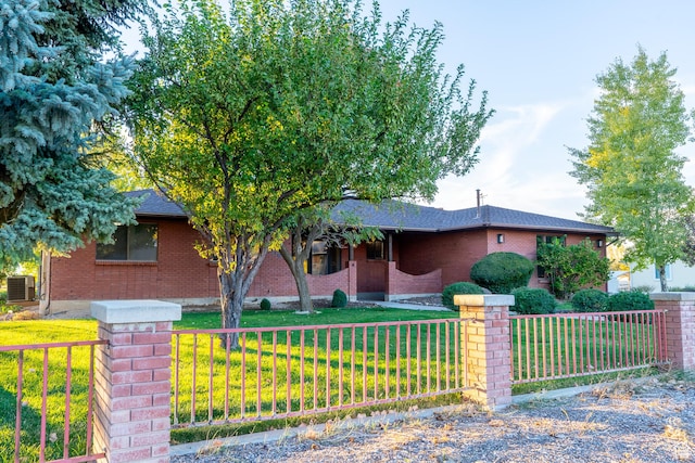 452 S 100 W, Salina, UT 84654 - view of front of home featuring a front lawn, roof with shingles, brick siding, a fenced front yard, and central air condition unit