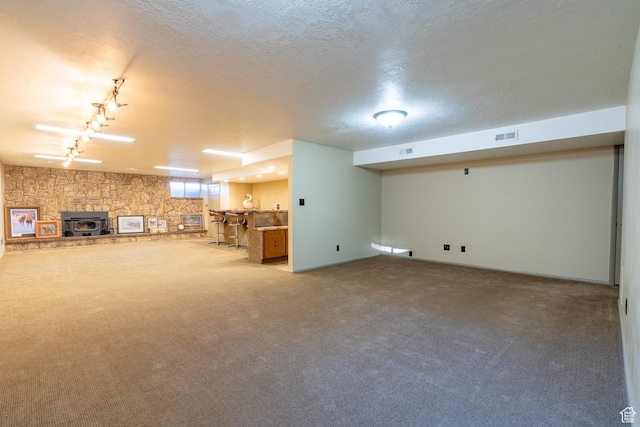 452 S 100 W, Salina, UT 84654 - basement with a wood stove, a textured ceiling, rail lighting, carpet, and visible vents