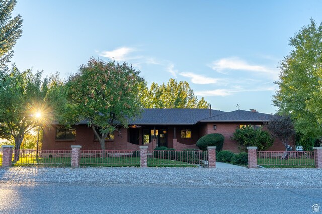 452 S 100 W, Salina, UT 84654 - ranch-style home featuring roof with shingles, covered porch, a fenced front yard, and brick siding
