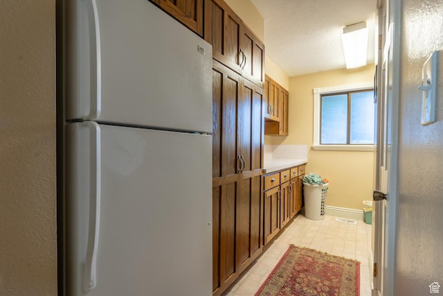 452 S 100 W, Salina, UT 84654 - kitchen featuring visible vents, freestanding refrigerator, brown cabinets, and light countertops