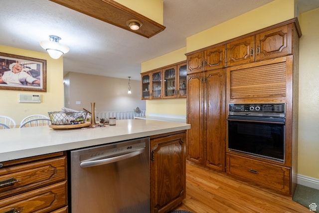 452 S 100 W, Salina, UT 84654 - kitchen with oven, brown cabinetry, light wood-style flooring, stainless steel dishwasher, and glass insert cabinets