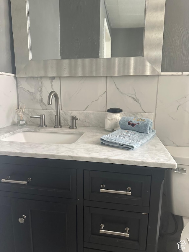 bathroom with vanity and tasteful backsplash