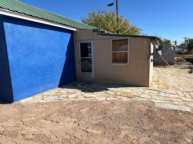 exterior space featuring metal roof and stucco siding