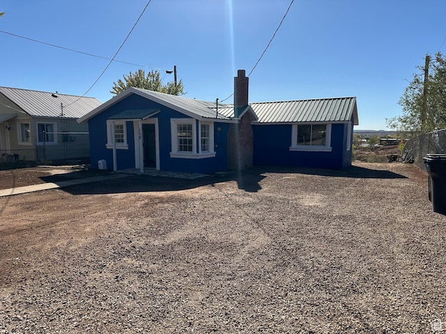 view of front of house featuring a chimney and metal roof