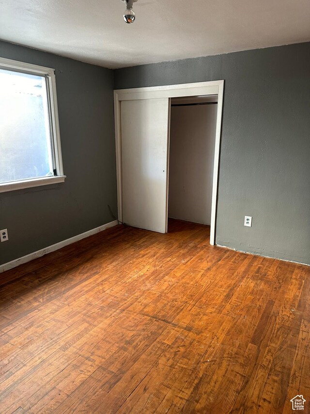 unfurnished bedroom featuring a closet and wood finished floors