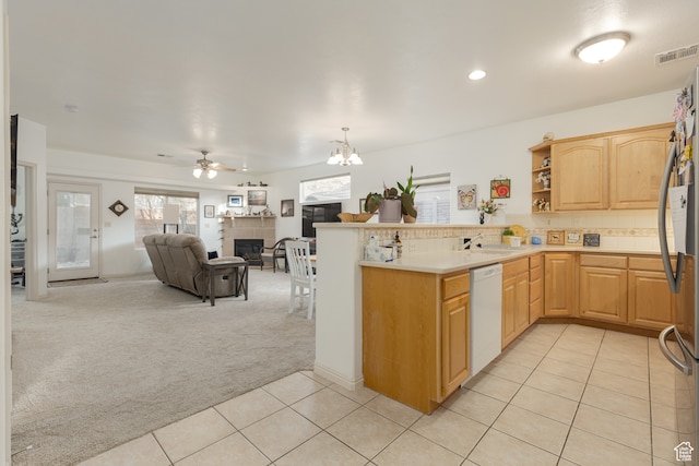 2331 S 675 W, Hurricane, UT 84737 - kitchen with light carpet, kitchen peninsula, white dishwasher, light brown cabinetry, and a fireplace