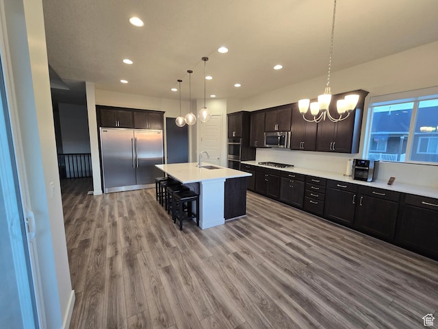 697 N 3275 W, Layton, UT 84041 - kitchen with stainless steel appliances, recessed lighting, wood finished floors, a chandelier, and a kitchen bar