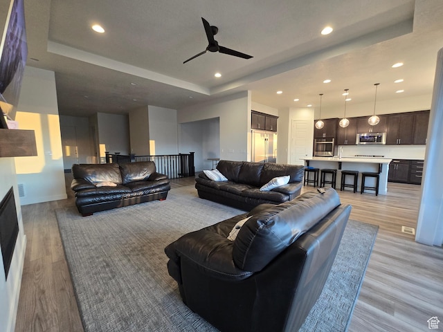 697 N 3275 W, Layton, UT 84041 - living area featuring light wood-style floors, ceiling fan, recessed lighting, and a tray ceiling