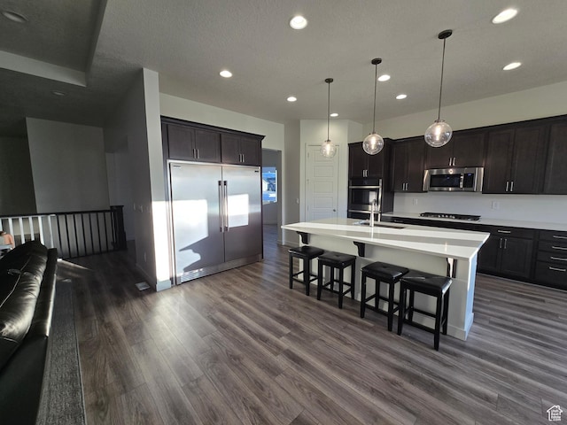 697 N 3275 W, Layton, UT 84041 - kitchen featuring stainless steel appliances, dark wood-type flooring, recessed lighting, light countertops, and a breakfast bar area